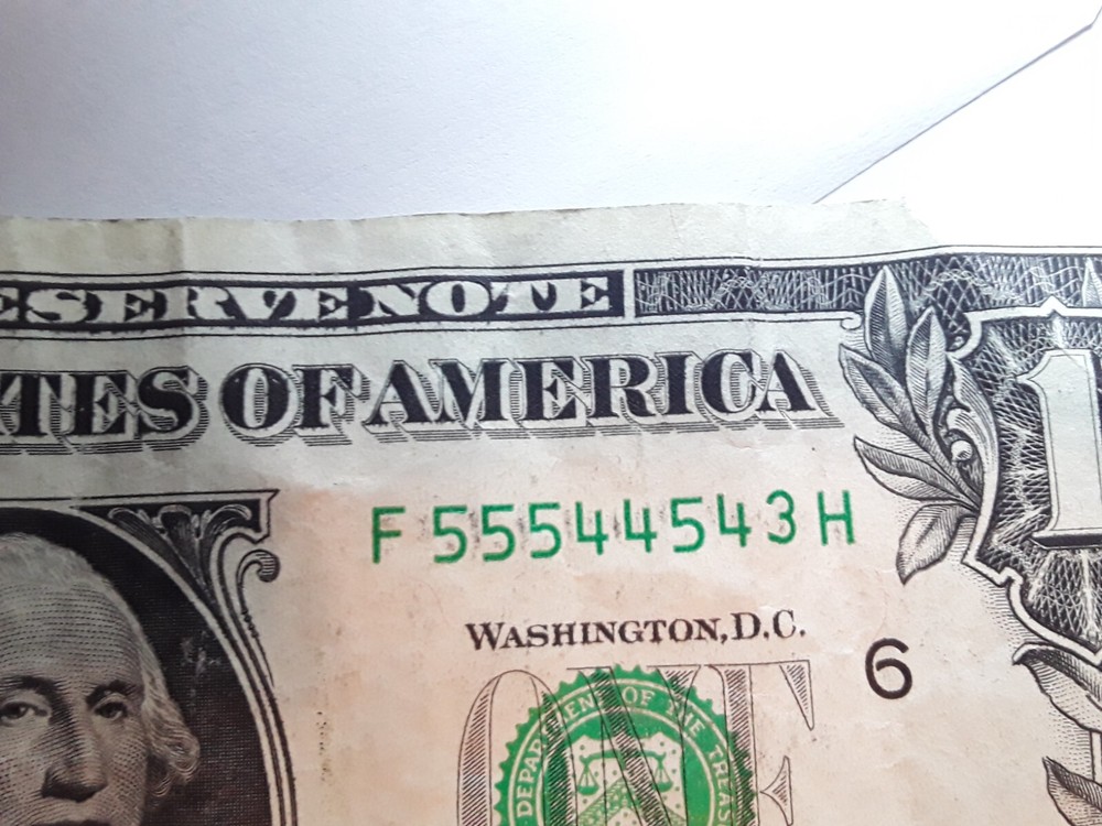 one dollar serial number print error. Ink between numbers
