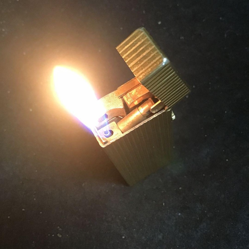 Overhauled gold dunhill lighter with striped pattern, ignition functioning well
